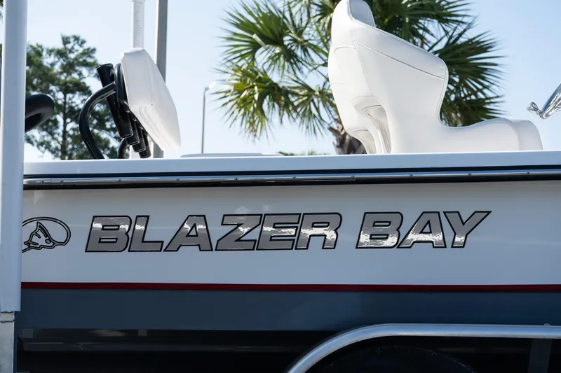 Slide: The Image of 2026 Blazer 675 Ultimate Bay boat with white seating and logo, palm tree background. - 3