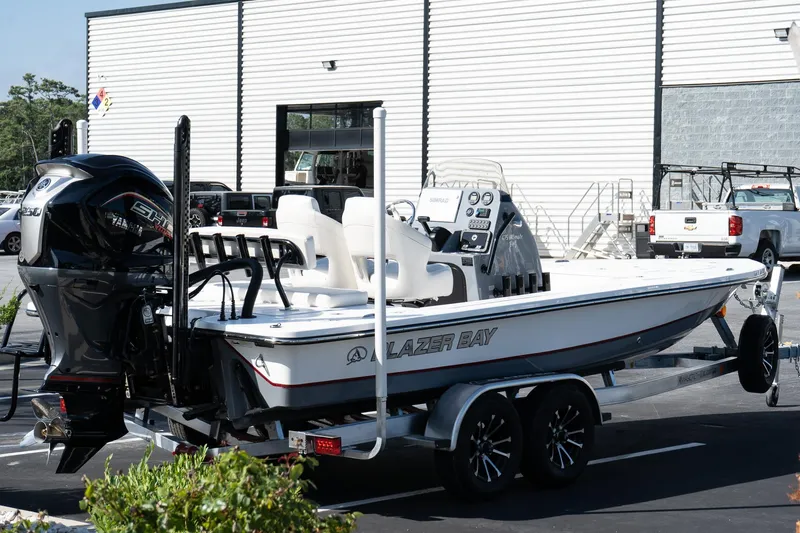 Slide: The Image of 2026 Blazer 675 Ultimate Bay boat on trailer, parked outside a building. - 4