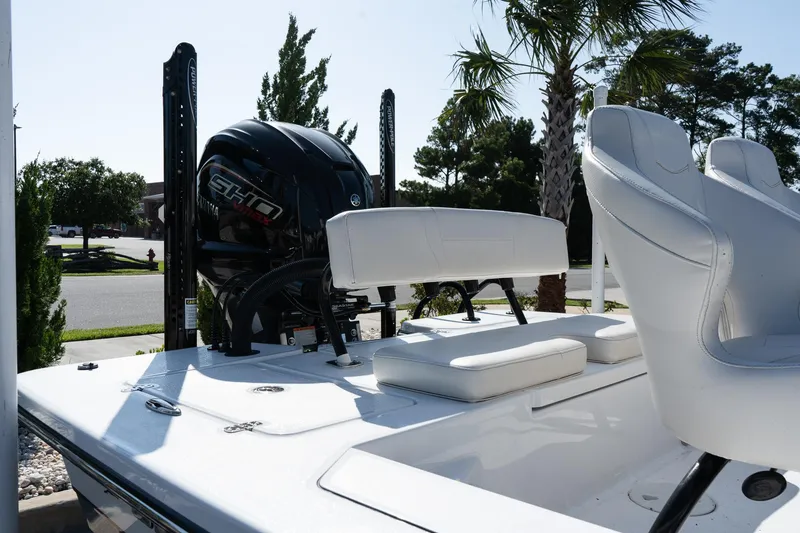 Slide: The Image of 2026 Blazer 675 Ultimate Bay boat with white seating and powerful engine, parked outdoors. - 8