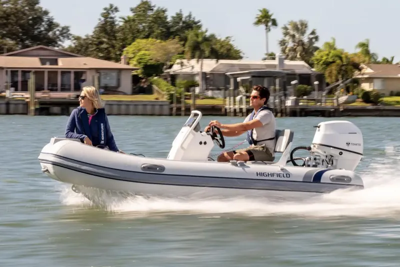 The Image of 2024 Highfield Classic 380 GT boat cruising on a sunny day with two passengers. - 0