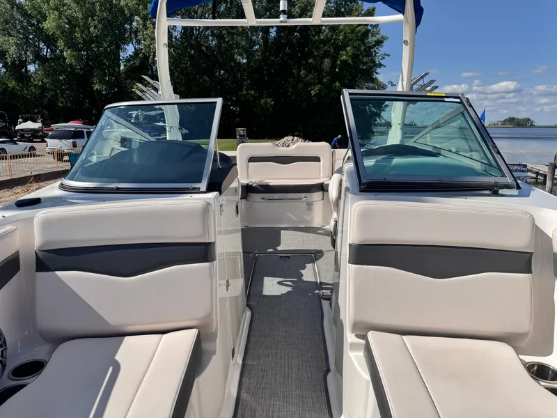 Slide: The Image of 2017 Chaparral 246 SSi boat interior with seating and steering wheel, docked near water. - 10