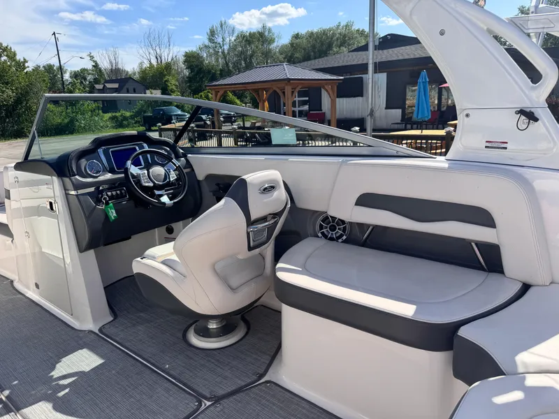 Slide: The Image of 2017 Chaparral 246 SSi boat interior with seating and helm, dockside view. - 18