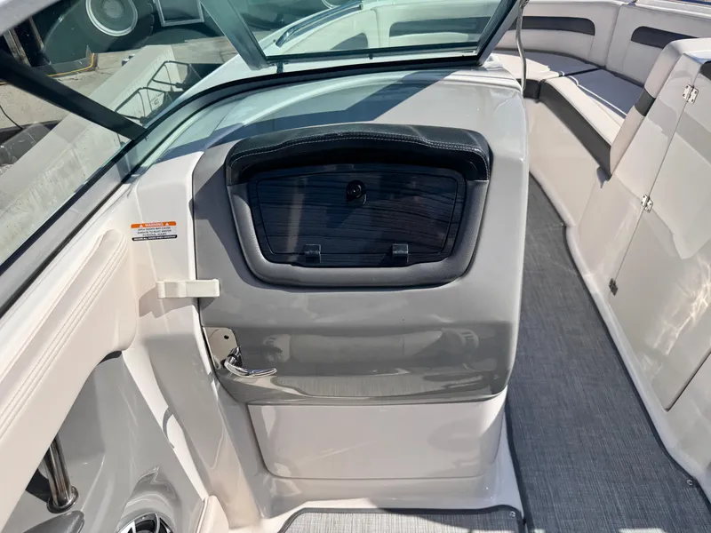 Slide: The Image of 2017 Chaparral 246 SSi boat bow with storage compartment on a concrete surface. - 29