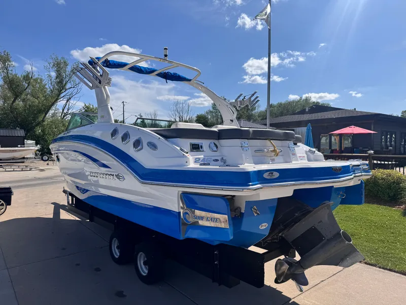 Slide: The Image of 2017 Chaparral 246 SSi boat on trailer, blue and white design, parked outdoors. - 6