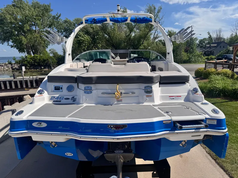 Slide: The Image of 2017 Chaparral 246 SSi boat on trailer, blue and white, parked near a lake. - 7