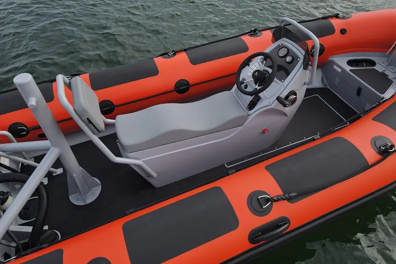 Slide: The Image of 2024 Highfield Patrol 420 boat with orange and black design, featuring a sleek console and seating. - 4