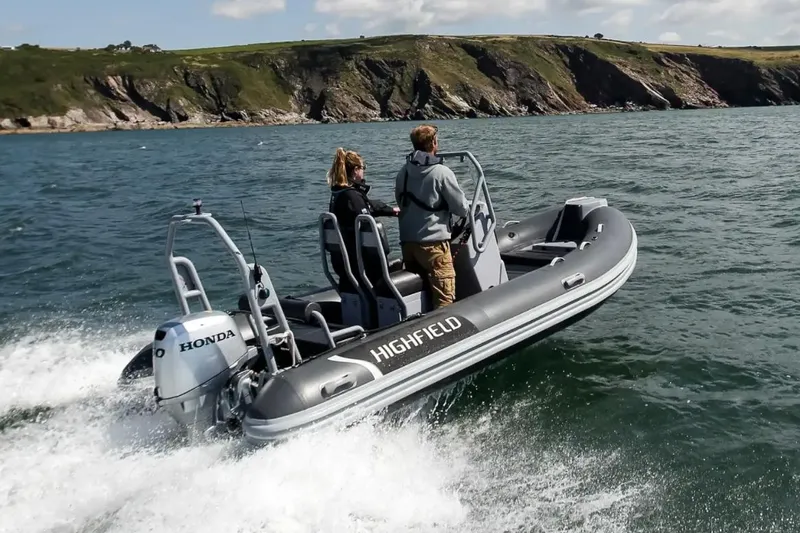 Slide: The Image of 2024 Highfield Classic 460 boat cruising on the ocean with two passengers. - 0