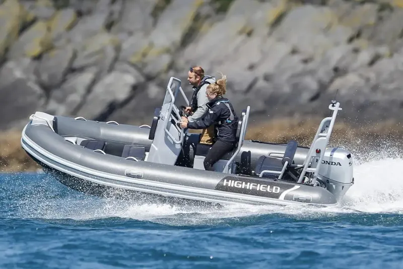 Slide: The Image of 2024 Highfield Classic 460 boat cruising on water with two passengers. - 1