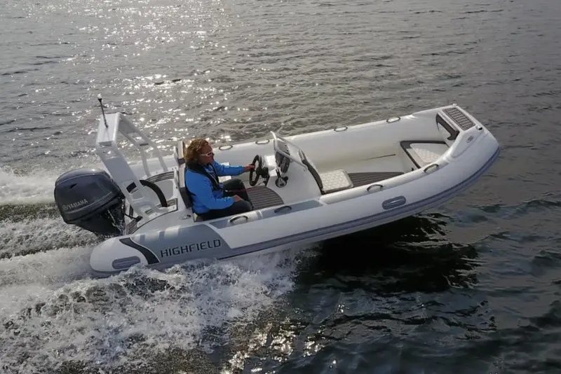 The Image of 2025 Highfield Sport 460 boat cruising on water with driver. - 0