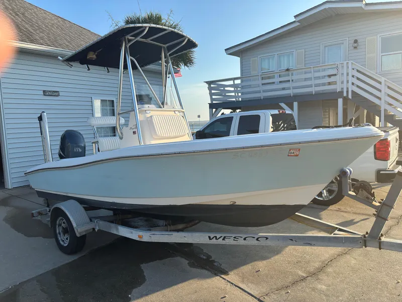 Slide: The Image of 2003 Pioneer 175 Bay Sport boat on trailer, parked near a house. - 2