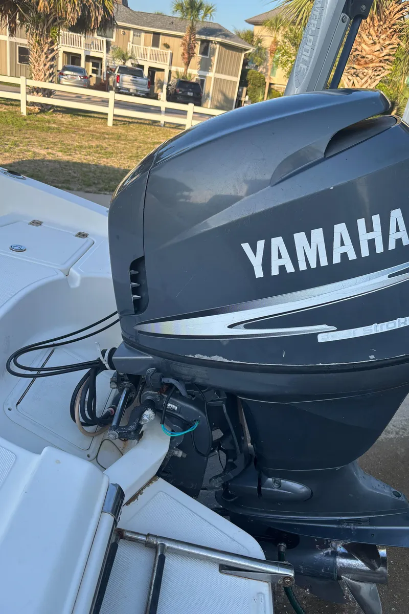 Slide: The Image of Yamaha outboard motor on 2003 Pioneer 175 Bay Sport boat, parked near palm trees. - 8
