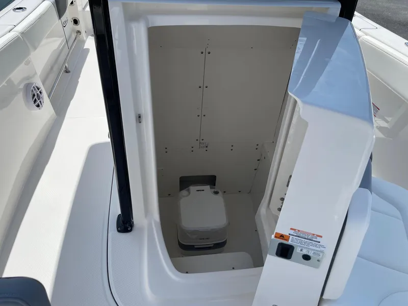 Slide: The Image of 2025 Robalo R230 Center Console boat interior with compact marine toilet. - 15