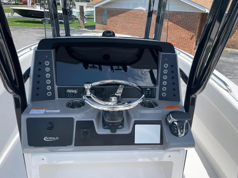 Slide: The Image of 2025 Robalo R230 Center Console boat dashboard with steering wheel and control panel. - 9