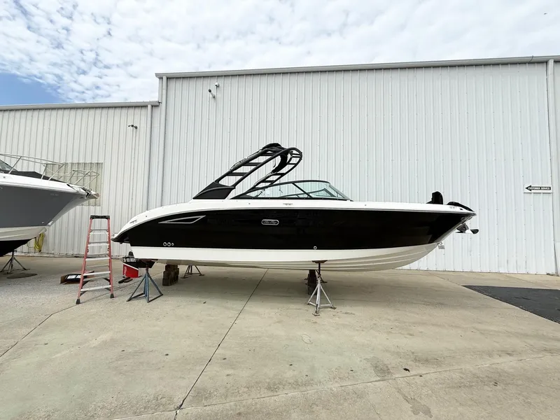 The Image of 2025 Sea Ray SDX 270 boat on stands outside a white building. - 1