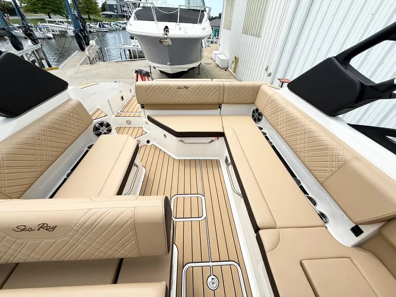 Slide: The Image of Luxurious 2025 Sea Ray SDX 270 boat interior with beige seating and wood-style flooring. - 6
