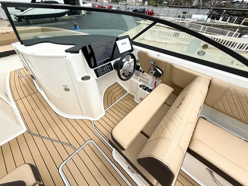 Slide: The Image of 2025 Sea Ray SDX 270 boat interior with beige seating and modern dashboard. - 7
