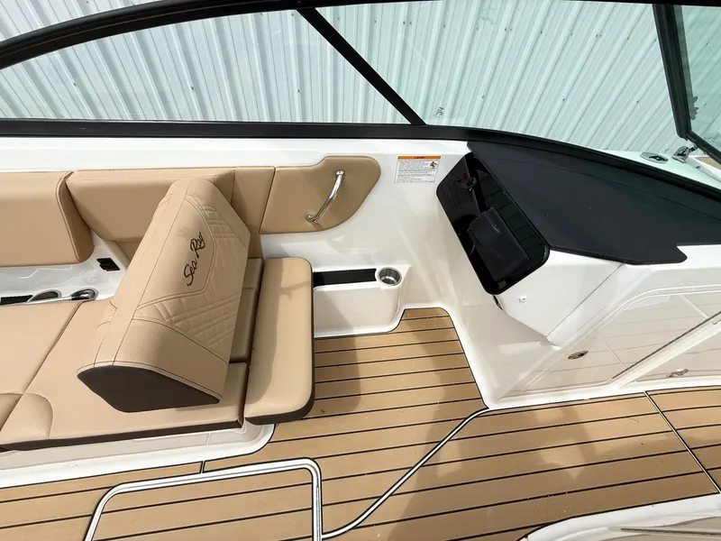 Slide: The Image of 2025 Sea Ray SDX 270 boat interior with beige seating and wood-style flooring. - 8