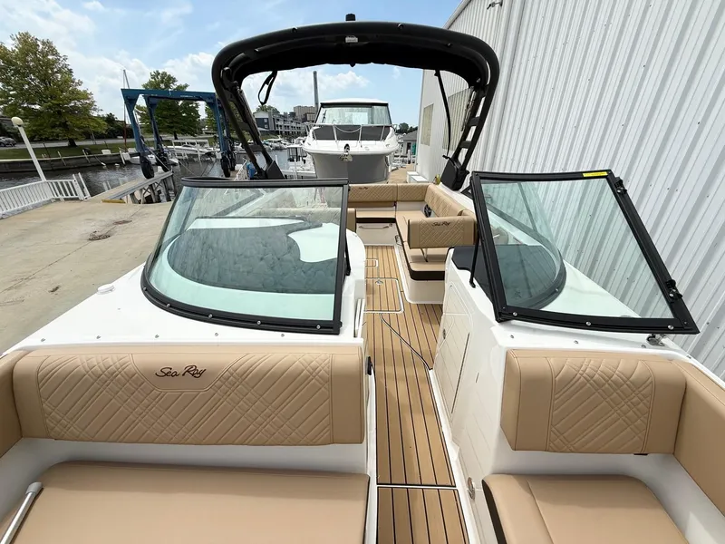 Slide: The Image of 2025 Sea Ray SDX 270 boat with tan seating and sleek design at a marina. - 9