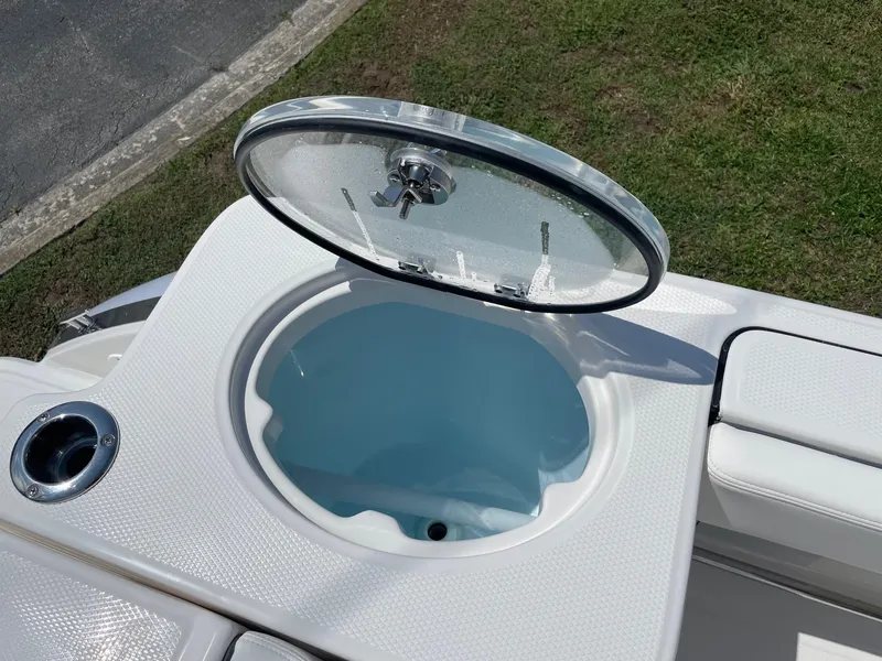 Slide: The Image of 2025 Robalo R230 Center Console livewell with open lid, showcasing interior design. - 10