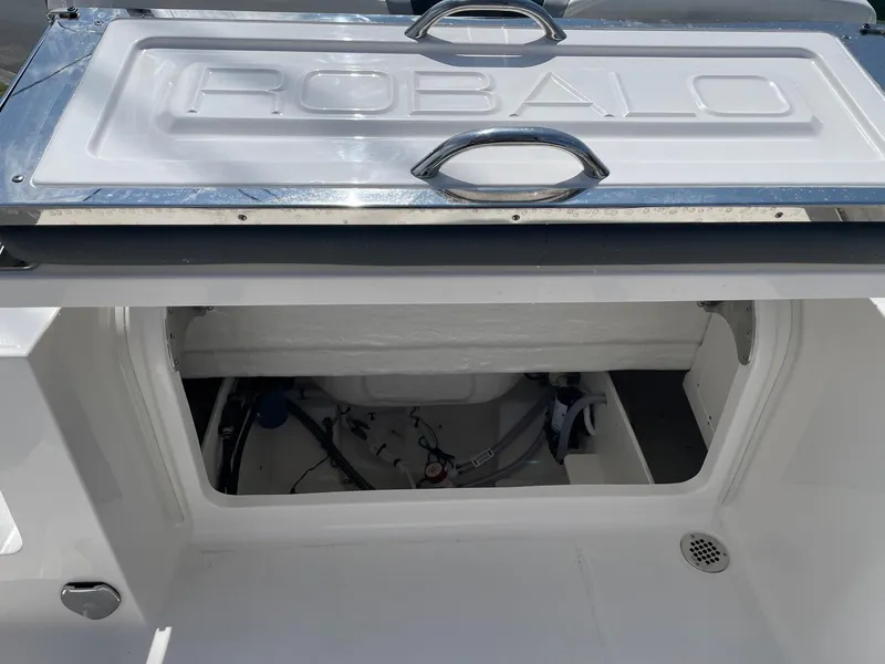 Slide: The Image of 2025 Robalo R230 Center Console storage compartment with open hatch. - 19