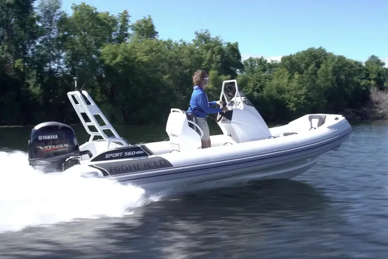 The Image of 2025 Highfield Sport 560 boat speeding on water with Yamaha engine, surrounded by trees. - 0