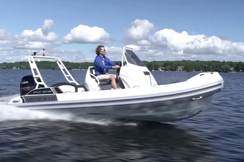 Slide: The Image of 2025 Highfield Sport 560 boat cruising on a lake under a clear blue sky. - 1