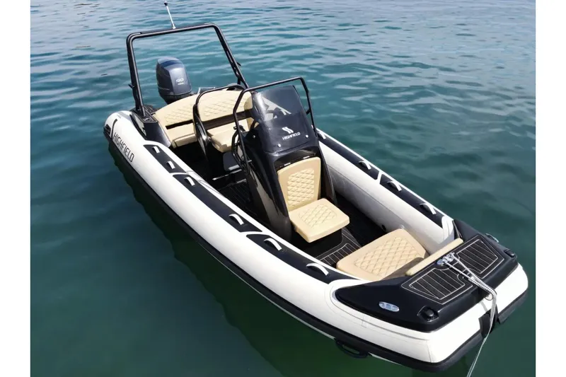 Slide: The Image of 2025 Highfield Sport 560 boat on calm water, featuring sleek design and comfortable seating. - 4