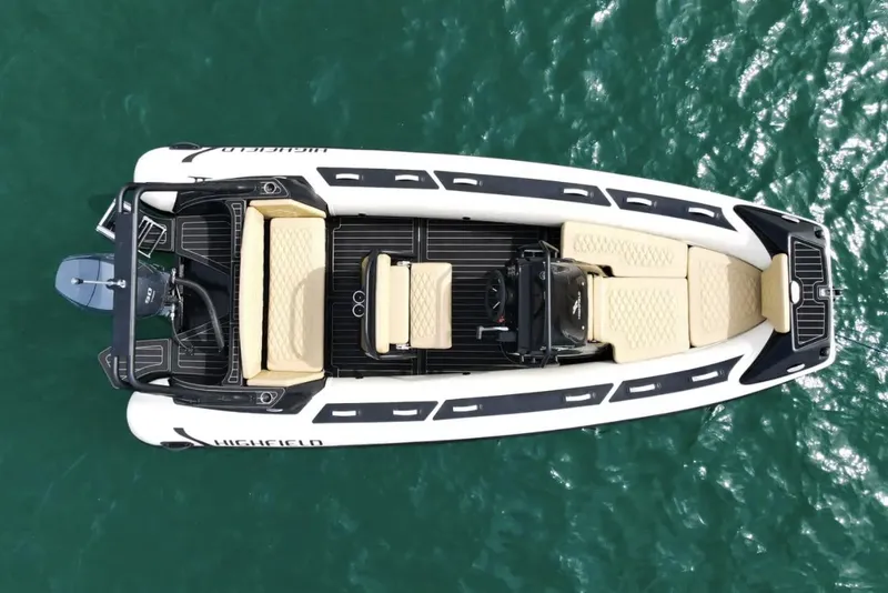 Slide: The Image of 2025 Highfield Sport 560 boat on water, aerial view, sleek design, beige seating. - 5
