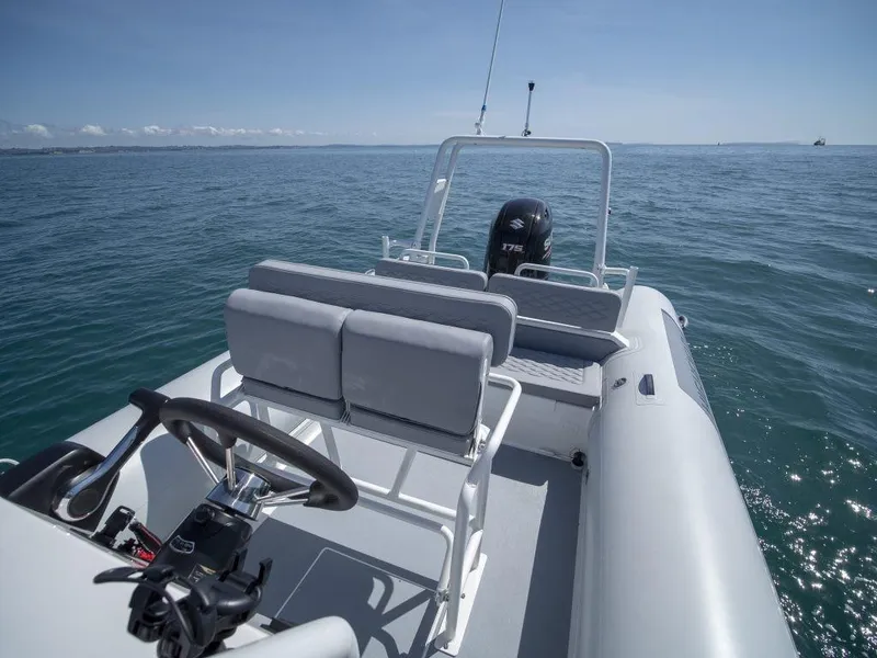 Slide: The Image of 2024 Highfield Patrol 600 boat on open water, featuring sleek design and modern seating. - 4