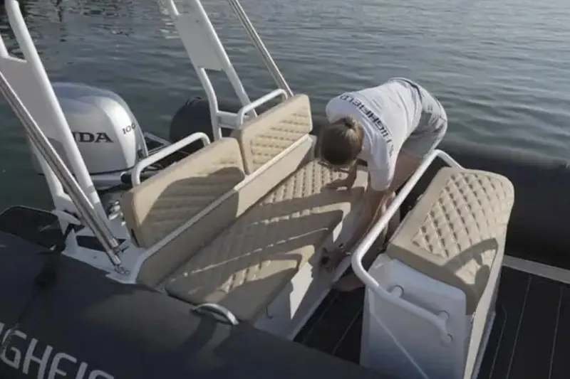 Slide: The Image of 2025 Highfield Sport 600 boat interior with cushioned seating and Honda engine. - 2