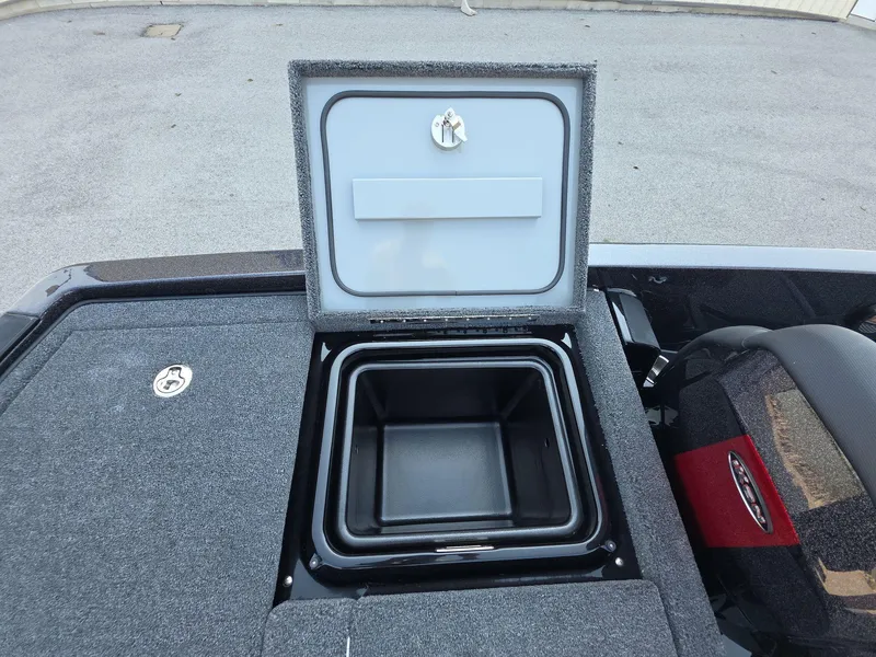 Slide: The Image of Open storage compartment on iKon LX21 boat, 2026 model, with gray carpeted surface. - 13