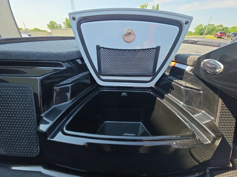 Slide: The Image of Open storage compartment in 2026 iKon LX21 boat, featuring a secure latch and netted pocket. - 17