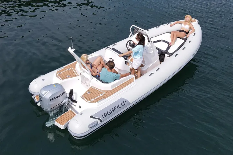 The Image of 2025 Highfield Sport 650 boat with passengers on water, featuring Honda outboard motor. - 0