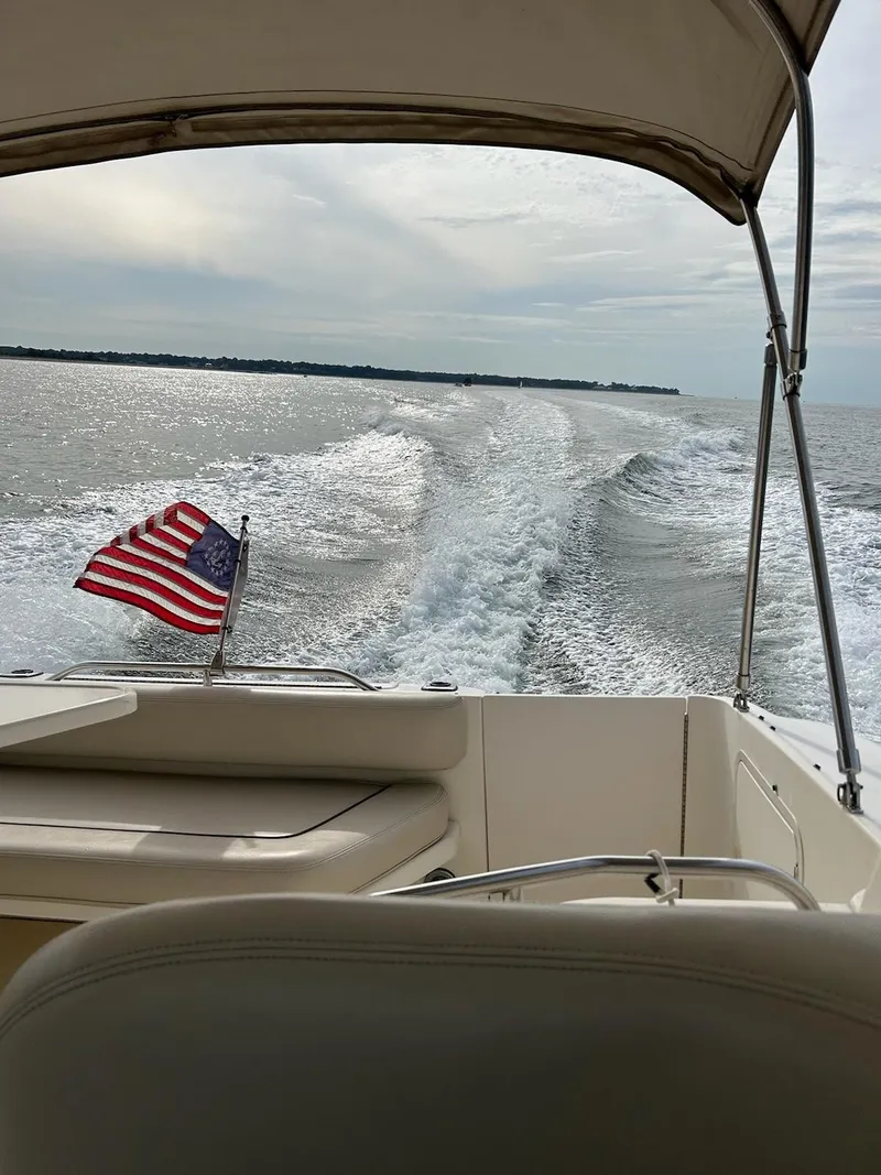 Slide: The Image of 1997 Sea Ray 290 Sundancer cruising with American flag, ocean view. - 3