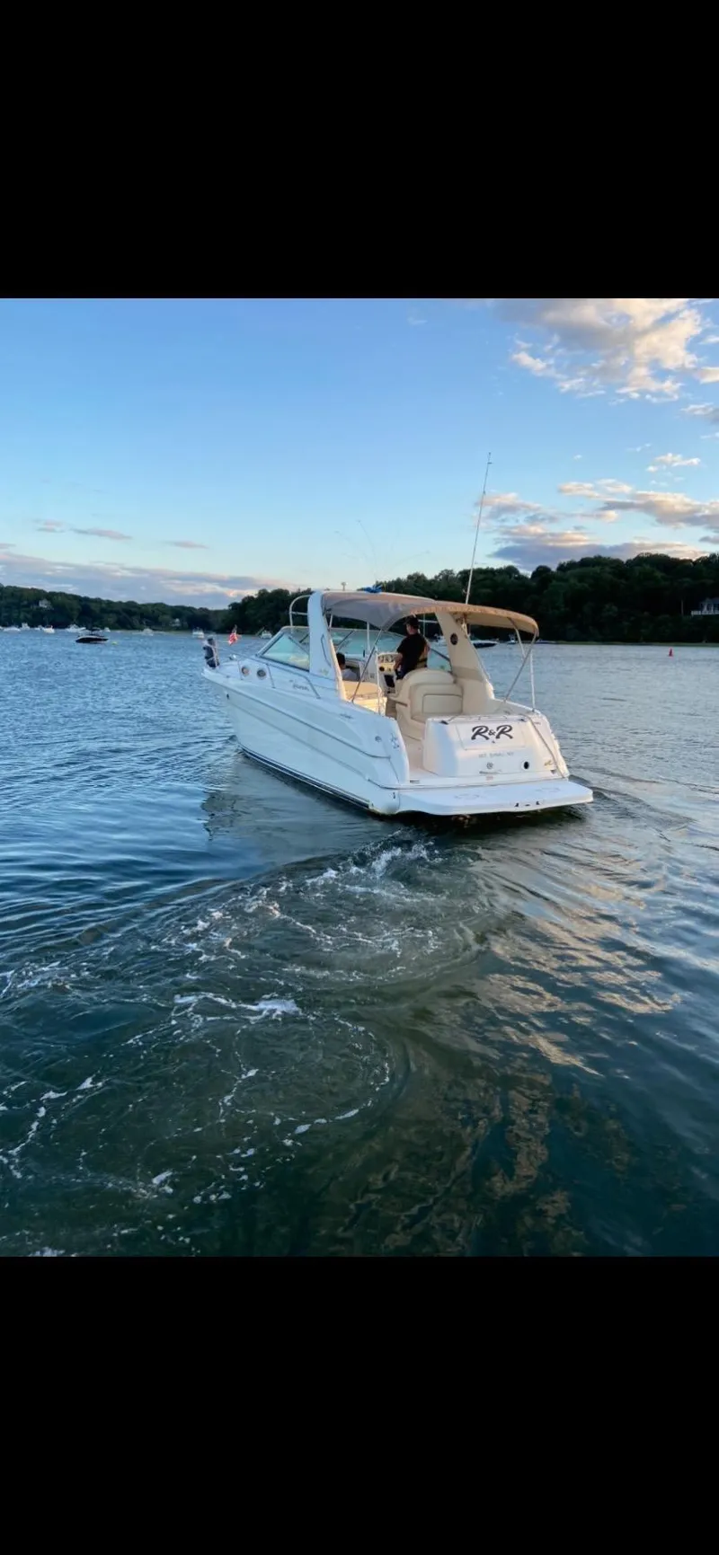 Slide: The Image of 1997 Sea Ray 290 Sundancer cruising on a serene lake at sunset. - 5