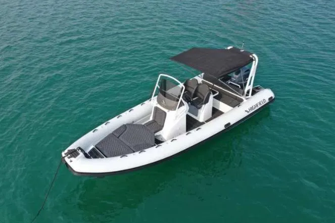 The Image of 2025 Highfield Sport 700 boat on clear water, featuring sleek design and canopy. - 0