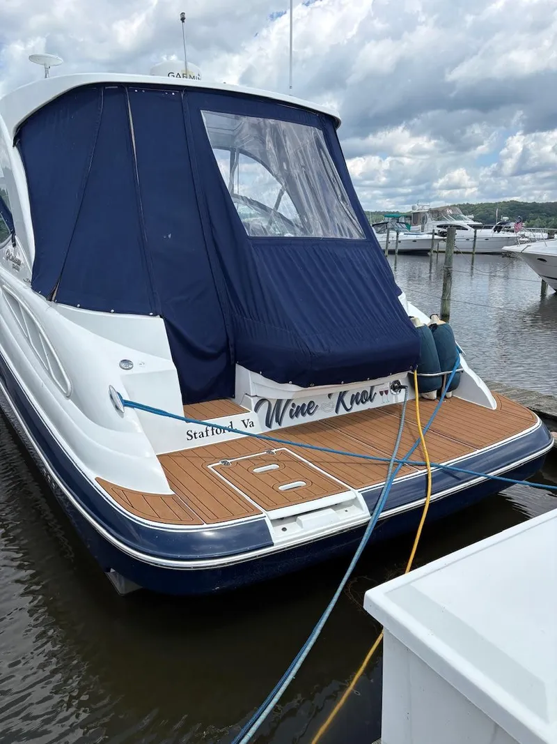 Slide: The Image of 2013 Cruisers Yachts 350 Express docked, featuring blue canopy and wooden deck. - 3