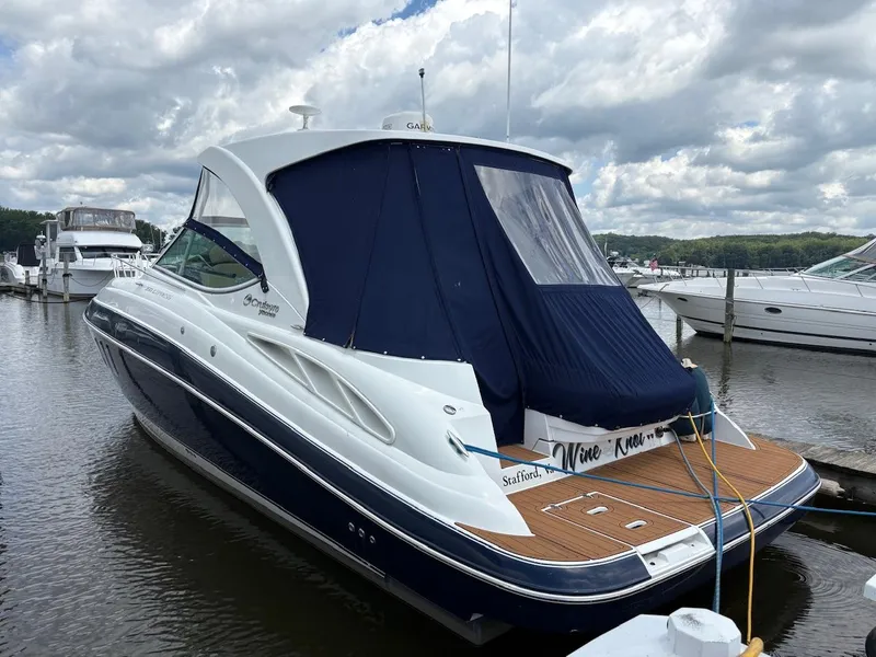Slide: The Image of 2013 Cruisers Yachts 350 Express docked, featuring sleek design and blue canopy. - 4