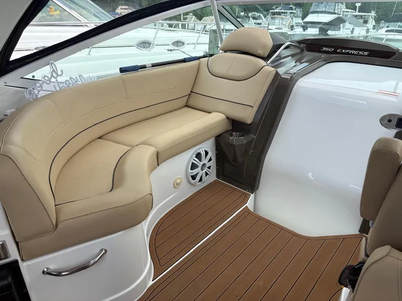 Slide: The Image of 2013 Cruisers Yachts 350 Express interior with beige seating and wood flooring. - 14