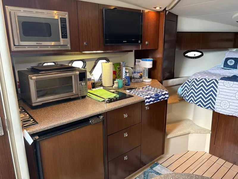 Slide: The Image of Interior of 2013 Cruisers Yachts 350 Express with kitchen and bed area. - 8