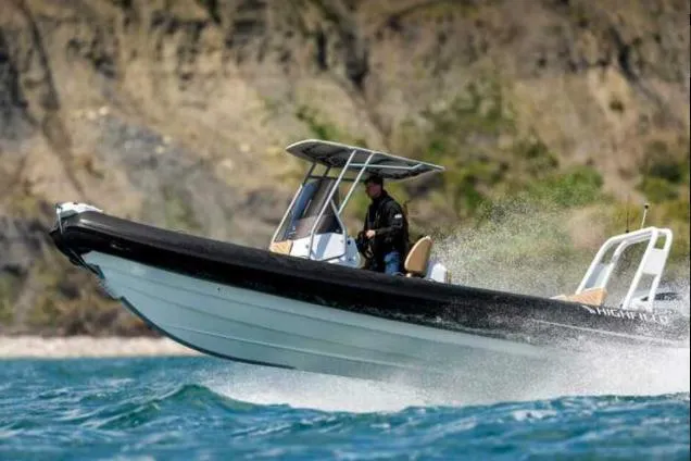 The Image of 2025 Highfield Sport 760 boat cruising on blue water near rocky shoreline. - 0