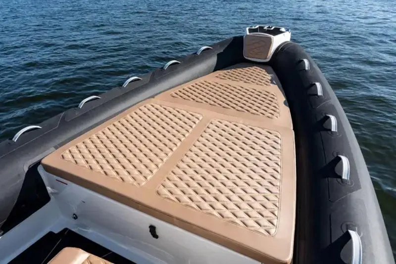 Slide: The Image of 2024 Highfield Sport 800 boat with cushioned deck on water. - 2