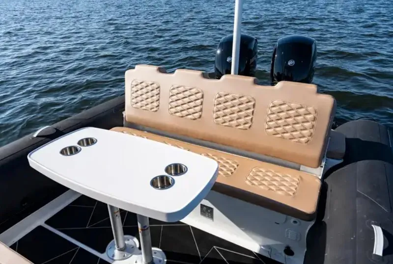 Slide: The Image of 2024 Highfield Sport 800 boat interior with cushioned seating and table on water. - 5