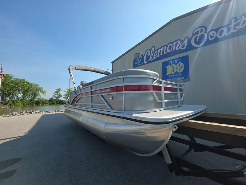 Slide: The Image of 2025 Bennington 20 SL pontoon boat at Clemons Boats dealership, sunny day. - 1