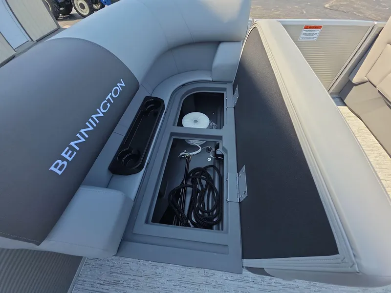 Slide: The Image of 2025 Bennington 20 SL boat storage compartment with open seat and visible accessories. - 15