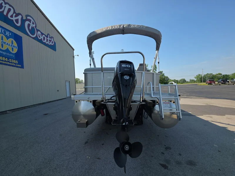 Slide: The Image of 2025 Bennington 20 SL pontoon boat with outboard motor, parked near dealership. - 4
