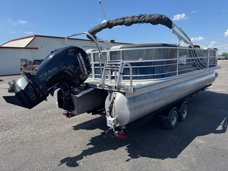 Slide: The Image of 2023 South Bay 224RS LE 2.75 Tritoon with Mercury outboard motor on trailer. - 3