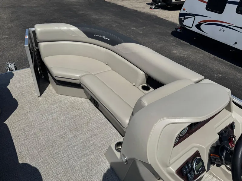 Slide: The Image of 2023 South Bay 224RS LE 2.75 Tritoon interior with beige seating and control panel. - 6