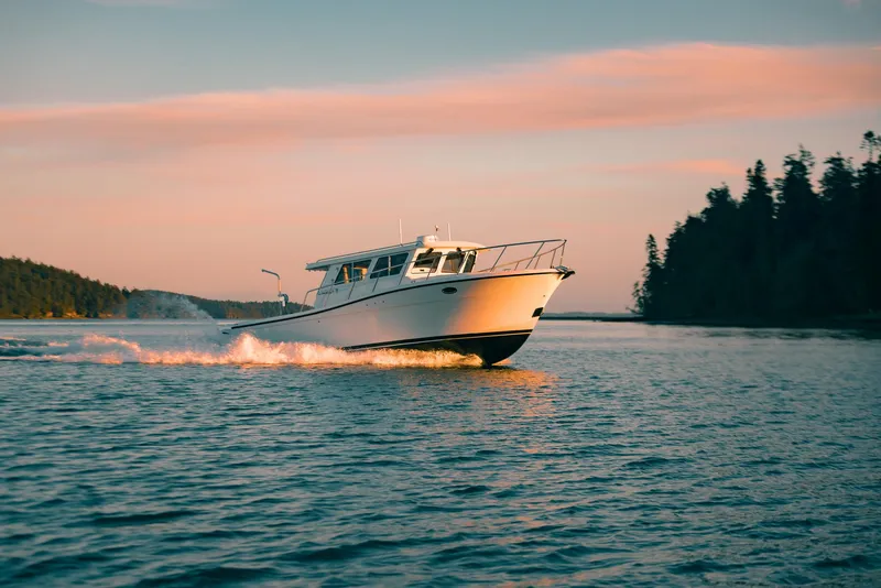 Slide: The Image of 2025 Lindell 38' boat cruising on serene water at sunset. - 16
