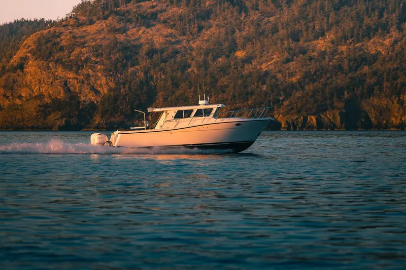 Slide: The Image of Lindell 38' 2027 boat cruising on serene water with scenic mountain backdrop. - 18